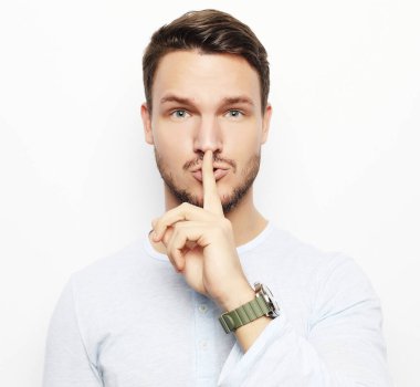 Beyaz arka planda şaşırmış genç bir adamın portresi