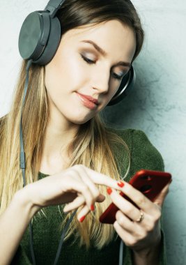 Günlük kıyafetli genç güzel bir kadın evde müziğin tadını çıkarıyor, yaşam tarzı kavramı.