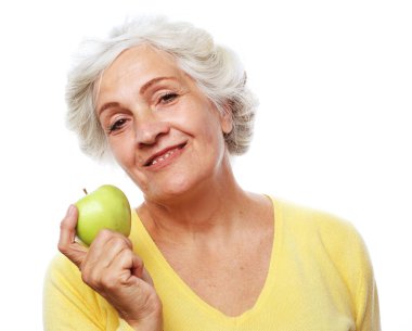 Yaşlılar ve yaşam tarzı konsepti: Mutlu yaşlı kadın beyaz arka planda elmayı elinde tutuyor