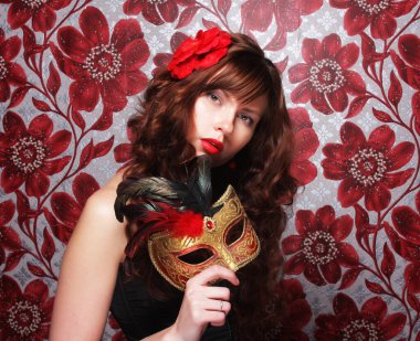 Uzun kıvırcık saçlı, maskeli esmer kadın. Parti için hazır..