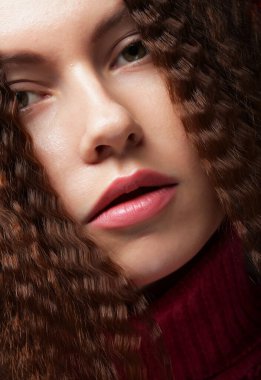 Uzun dalgalı saçlı güzel bir kız. Kıvırcık saçlı esmer. Resmi kapat.