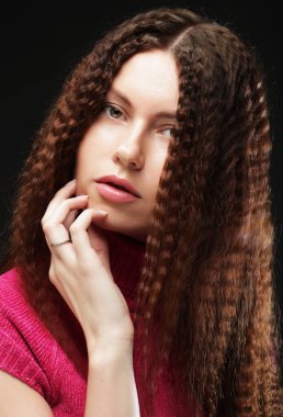 Uzun dalgalı saçlı güzel bir kız. Kıvırcık saçlı esmer. Resmi kapat.