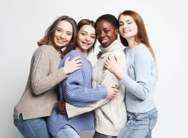 Arkadaşlık, feminizm ve halk konsepti: Sıradan kıyafetler giyen çekici çok ırklı kızların portresi.