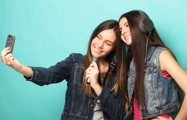Mikrofonlu iki güzel hippi kadın selfi çekiyor.