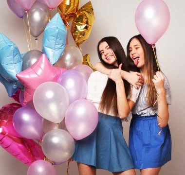 Yaşam tarzı, insanlar, gençler ve arkadaşlık konsepti - Beyaz arka planda balonları olan güzel genç kızlar