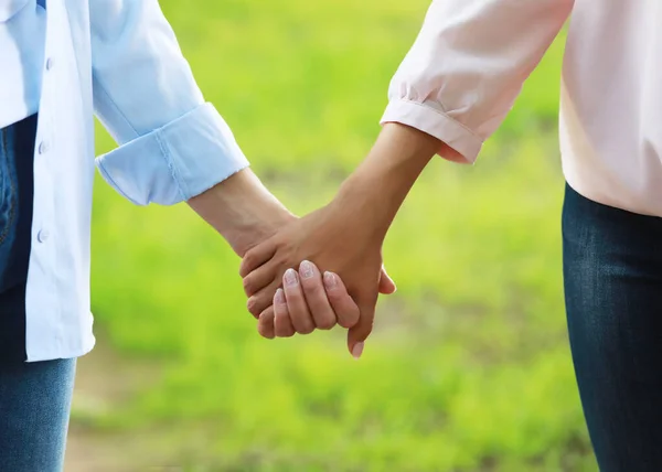 Elderly Mother holding a hand of her adult daughter in summer day outdoors — Stock Photo, Image