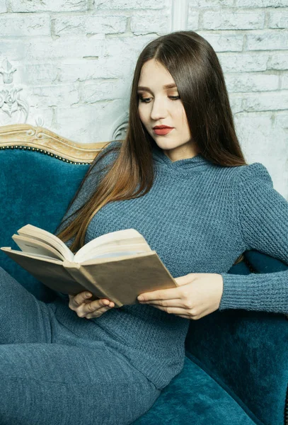 Молода блондинка розслабляється вдома і читає книгу — стокове фото