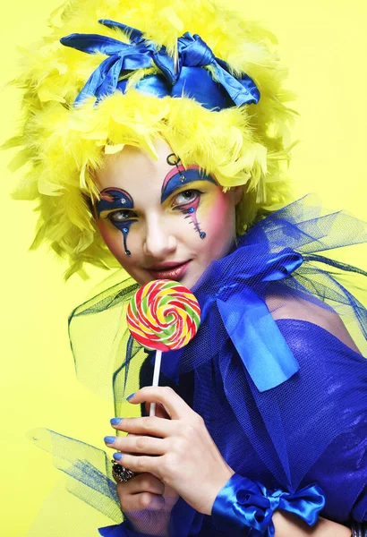 Lolipopu olan yaratıcı görünüşlü genç bir kadın. Parti ve karnaval. Parlak peruk. — Stok fotoğraf