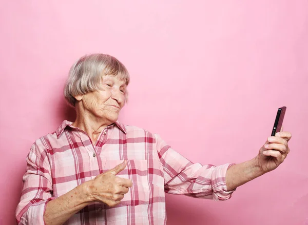 Životní styl, tehnologie a pojetí starých lidí: Obrázek veselé dospělé starší ženy s mobilním telefonem. — Stock fotografie