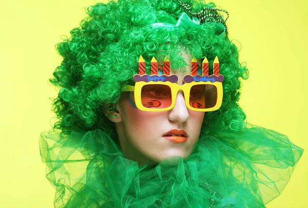 緑のウィッグと大きなパーティーグラスを持つ若い女性。休日のテーマ. — ストック写真