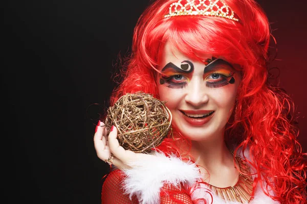 赤い巻きウィッグと王冠の若い女性。プリンセススタイル。パーティーやカーニバルのための創造的なメイク. — ストック写真