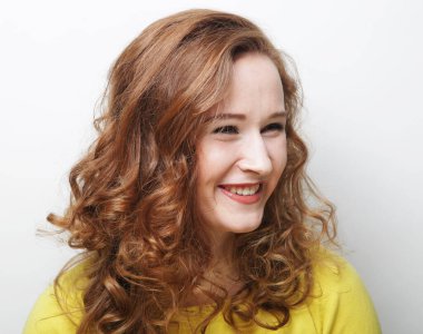 Duygu ve insan kavramı: güzel sarışın genç bir kadın, beyaz arka planda gülümsüyor ve gülüyor.