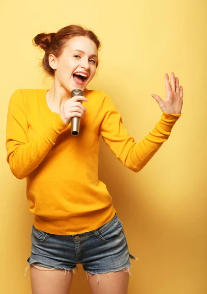 穿着带麦克风的黄色套头毛衣的美女. — 图库照片