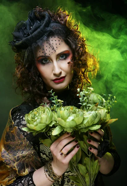 Hermosa mujer con brillante creativo maquillaje sosteniendo flores secas sobre fondo negro —  Fotos de Stock