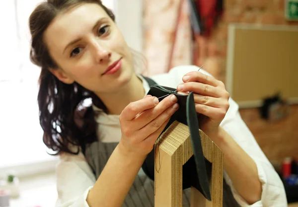 Giovane donna lavora in uno studio di produzione di borse, ritaglia i dettagli — Foto Stock