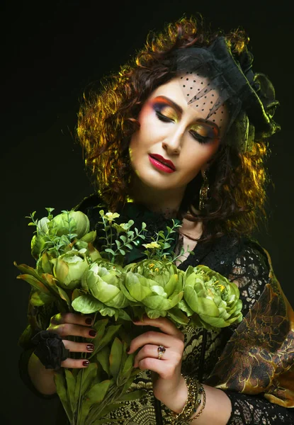 Beautiful woman with bright creative make up holding dry flowers over black background — Stock Photo, Image