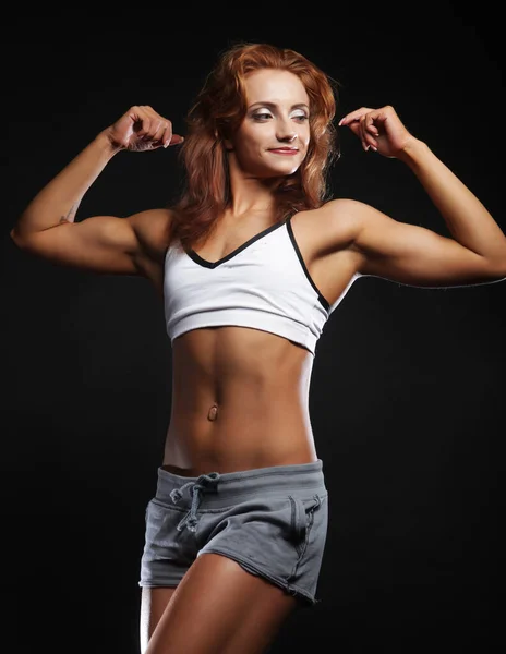 Photo of cheerful young red haired woman dressed sportwear over black background. — Stock Photo, Image