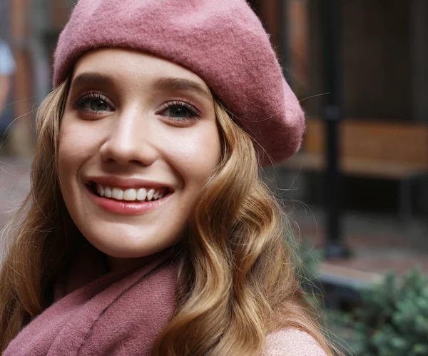 Außenporträt einer jungen schönen Frau mit langen welligen Haaren, die rosa Baskenmütze und Schal trägt, Sommertag — Stockfoto