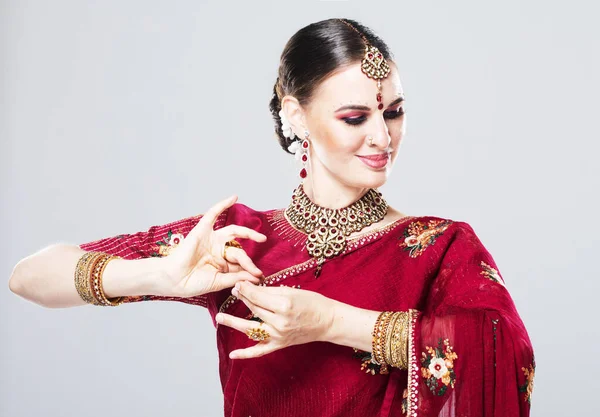 Mujer india en ropa tradicional bailando sobre fondo gris — Foto de Stock