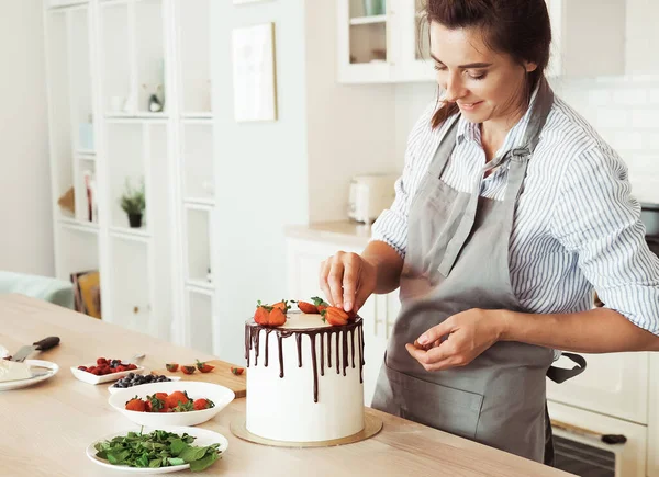 Pastry chef decorates the cake with berries — Stock Photo, Image