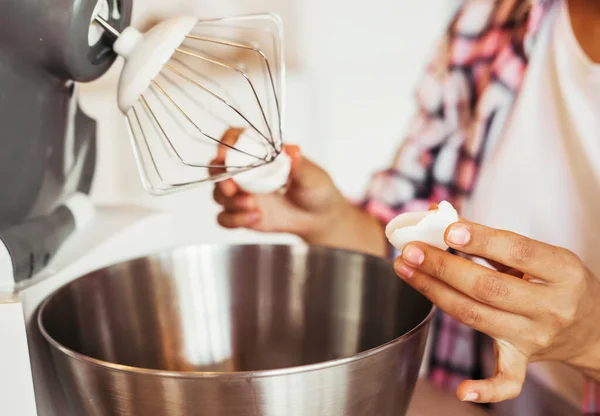 Крупным планом женские руки разбивают яйцо в миску кухонной машины для взбитых сливок или теста — стоковое фото
