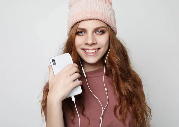 Style de vie et concept de personnes : jeune femme dans un casque avec smartphone à l'écoute de la musique. — Photo