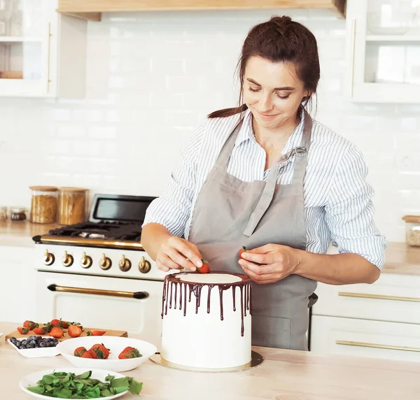 Pastry chef decorates the cake with berries — Stock Photo, Image