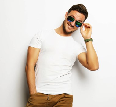 Zarif, genç, yakışıklı, akıllı, rahat giyimli ve güneş gözlüklü..