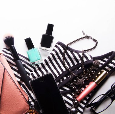 Gözlükleri, temeli, dudak parlatıcısı, pudrası, fırçası, el çantası, çizgili gömleği olan stilize kadın bezi.