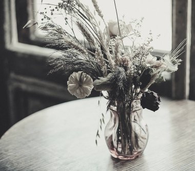 Masanın üzerinde kurumuş çiçekler var.