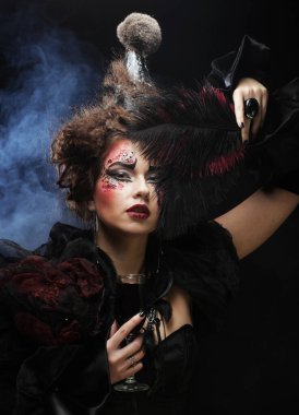 Gotik makyajlı ve deli saçı olan genç bir kadın. Yaratıcı moda maskesi.