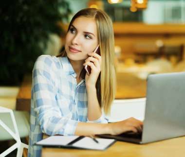 Cafe 'de dizüstü bilgisayar kullanan bir iş adamı. Genç ve güzel bir kız.
