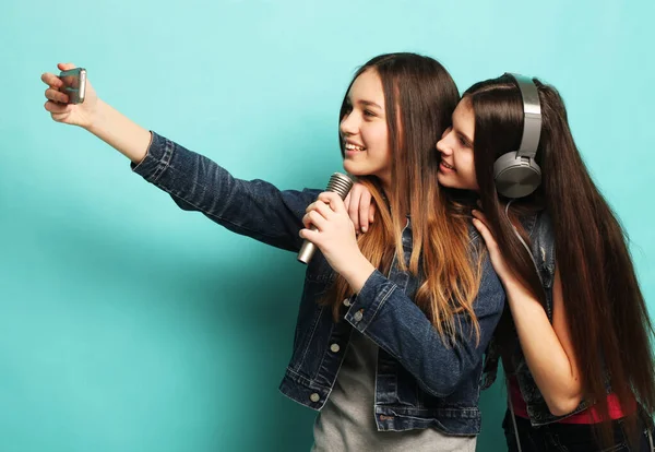 Lifestyle, geluk, emotie en mensen concept: beauty hipster tieners met een microfoon zingen en neem foto met smartphone — Stockfoto