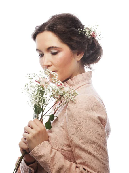 Ung brunett kvinna i rosa klänning håller en bukett rosor och drömmer om kärlek — Stockfoto