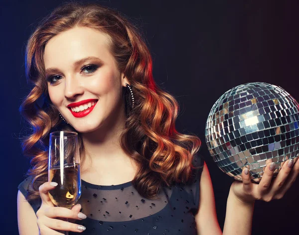 Giovane donna che tiene un bicchiere di vino e discoteca palla al night club — Foto Stock
