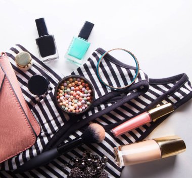 Gözlükleri, temeli, dudak parlatıcısı, pudrası, fırçası, el çantası, çizgili gömleği olan stilize kadın bezi.