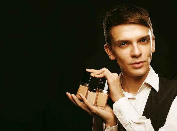 Молодой мужчина позирует с фундаментом для макияжа — стоковое фото