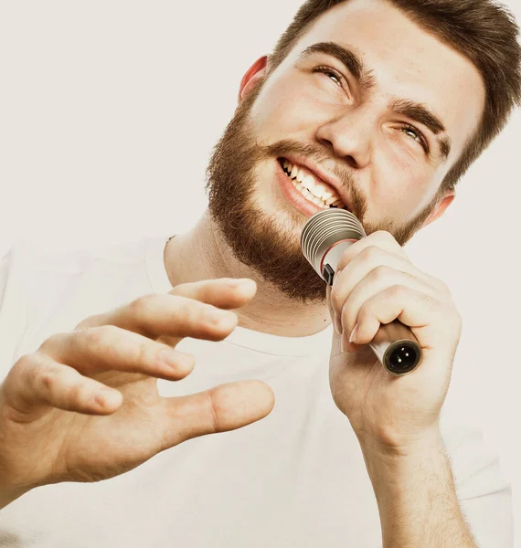 Ο διασκεδαστής. Νεαρός άνδρας που μιλάει κρατώντας μικρόφωνο, απομονωμένος σε λευκό φόντο. — Φωτογραφία Αρχείου