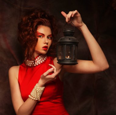 Tiyatro arka planında poz veren kırmızı elbiseli güzel bir esmer.