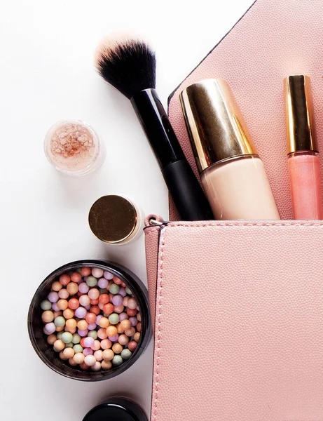 Divat koncepció: Lapos laikus rózsaszín bőr nő táska nyitott ki a kozmetikumok és kiegészítők fehér alapon. — Stock Fotó