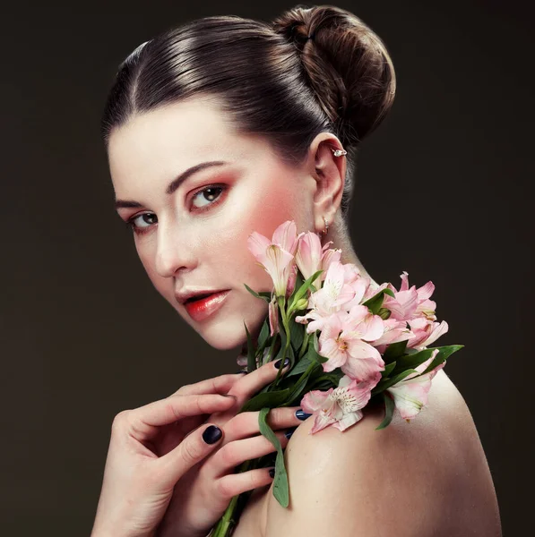 Hermosa mujer joven con maquillaje en colores suaves sostiene una gran flor rosa, concepto de belleza —  Fotos de Stock