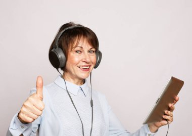 Yaşam tarzı, tehnoji ve insan konsepti: Yaşlı bir kadın tablet kullanarak yeni bir meslek edinir.