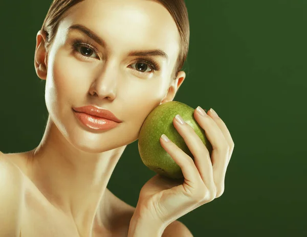 Mujer joven con manzana verde sobre fondo verde — Foto de Stock