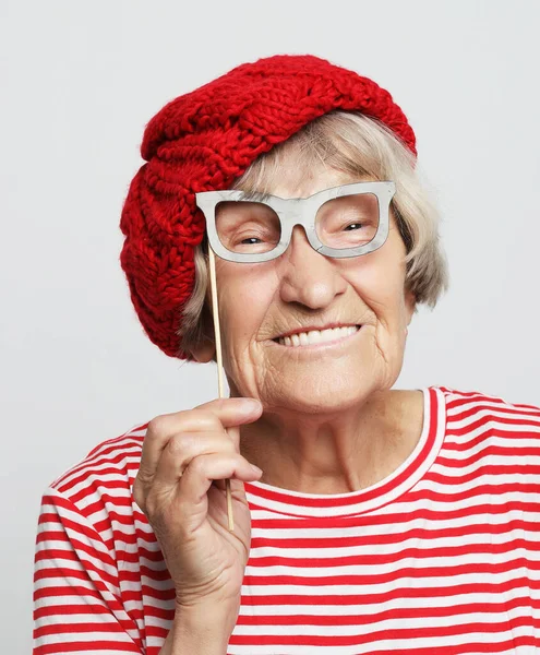 Lifestyle, emotion and people concept: funny grandmother with fake glasses, laughs and ready for party — Stock Photo, Image