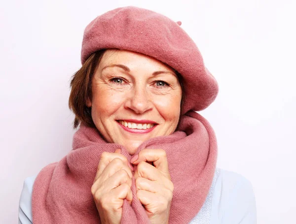 Usmívající se stará žena v růžovém šátku a baretu — Stock fotografie