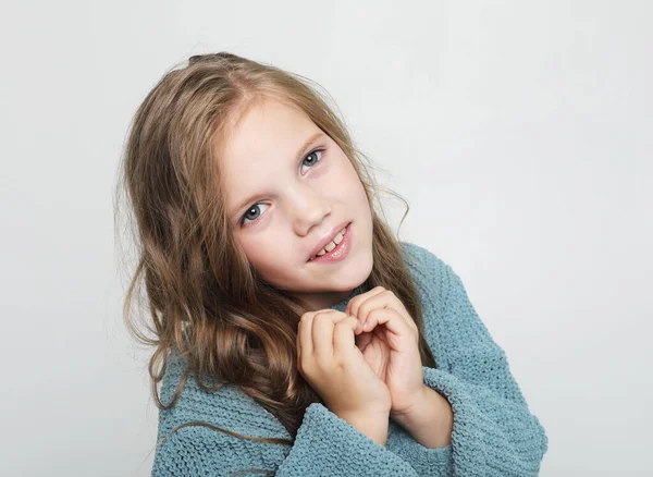 Mooi blond klein meisje dragen casualblue trui glimlachen op camera geïsoleerd over grijze achtergrond — Stockfoto