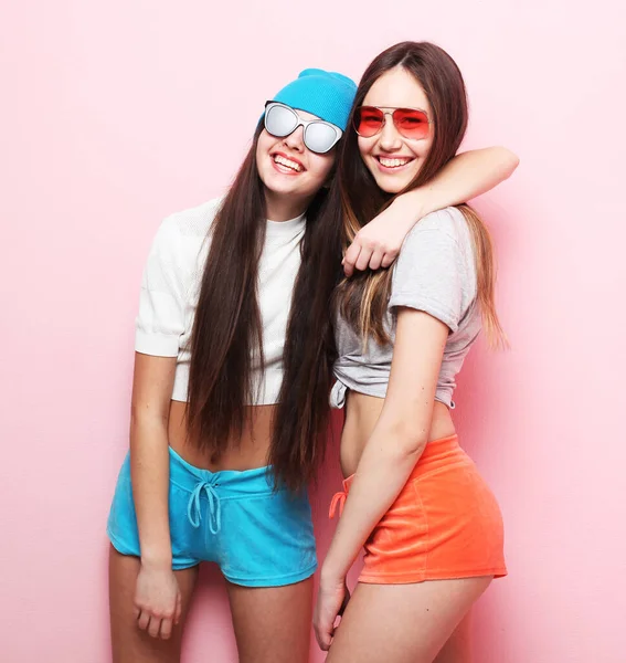 Estilo de vida y el concepto de la gente: Dos jóvenes amigas adolescentes de pie juntas y divirtiéndose. —  Fotos de Stock