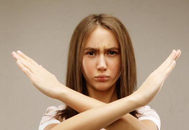 Güzel genç bayan gri arka plana hayır diyor.