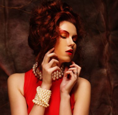 Şehvetli, güzel esmer kadın kırmızı elbise içinde poz veriyor. Sanat ve moda