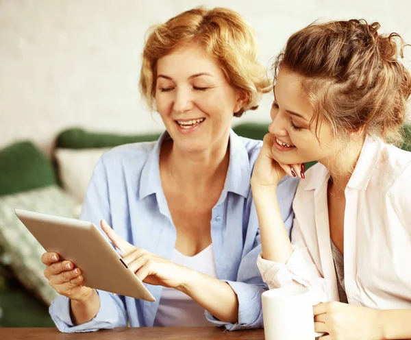 Lifestyle, tehnology and people concept: μητέρα και ενήλικη κόρη χρησιμοποιώντας τον υπολογιστή tablet στο σπίτι — Φωτογραφία Αρχείου